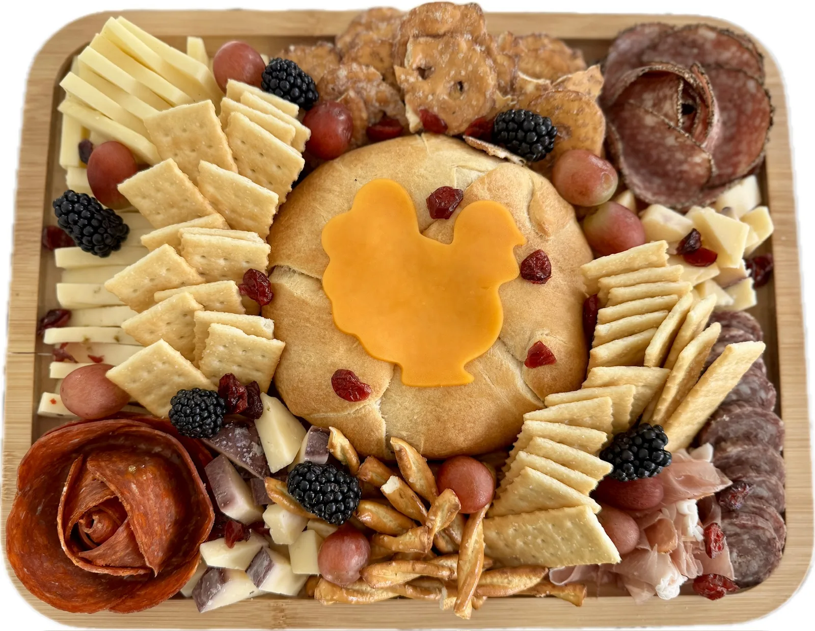 Baked cranberry brie charcuterie board with cheese in the shape of a Thanksgiving turkey on it